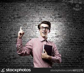 Young erudite. Young man in casual with book in hands