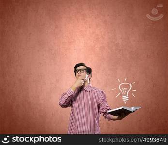 Young erudite. Young man in casual with book in hands