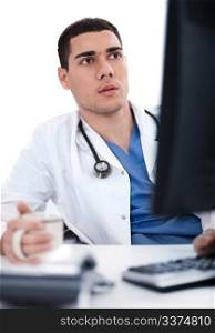 Young ethnic doctor looking deeply at the computer in his office