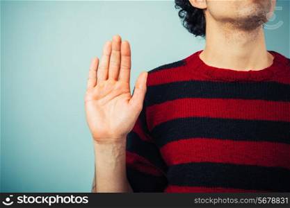 Young ethnic man is pledging allegience with his right hand raised