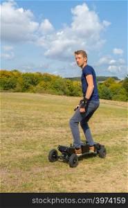 Young european man rides electrical mountainboard offroad