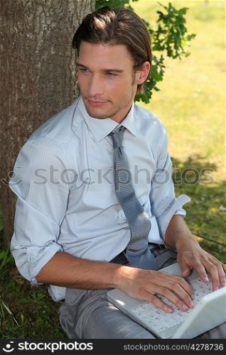 Young exec using his laptop in the park