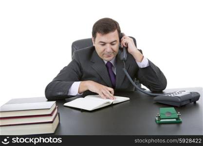 young executive at work and talking on phone at his desk. Isolated on a white background.