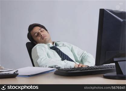 Young executive sleeping at work