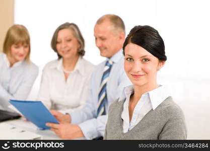 Young executive woman looking camera during meeting with team colleagues