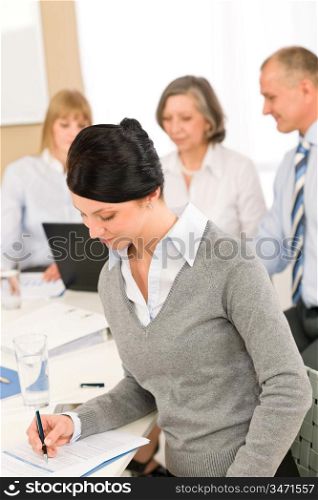 Young executive woman take notes during meeting with team colleagues