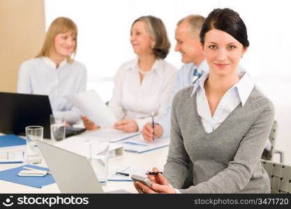 Young executive woman use phone during meeting with team colleagues