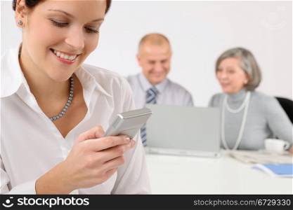 Young executive woman use phone during meeting with team colleagues