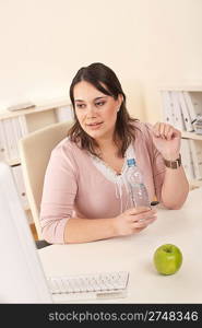 Young executive woman with bottle of water at office having break for drink