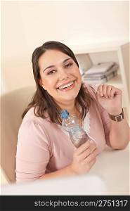 Young executive woman with bottle of water at office having break for drink