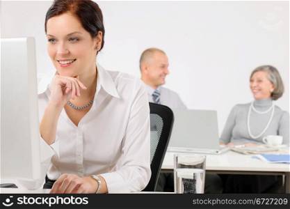 Young executive woman work on computer in office with colleagues