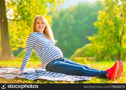 Young expectant mother comfortable resting in the park