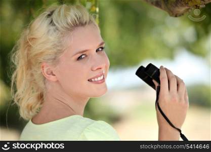 Young fair-haired woman with binoculars