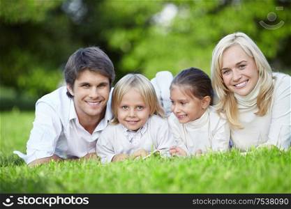 Young families with children lying on the grass in the park