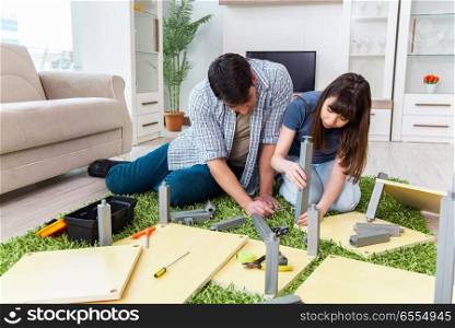 Young family assembling furniture at new house