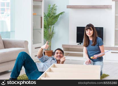 Young family assembling furniture at new house