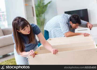 Young family assembling furniture at new house