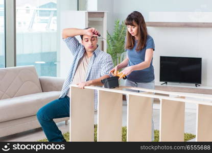 Young family assembling furniture at new house