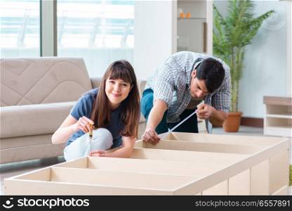 Young family assembling furniture at new house