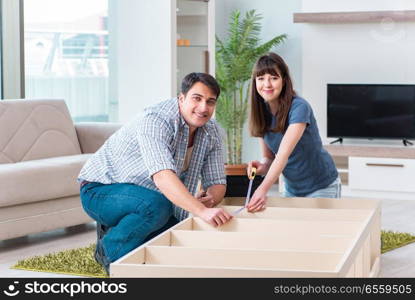 Young family assembling furniture at new house