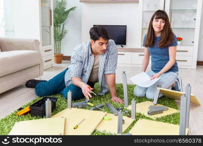 Young family assembling furniture at new house