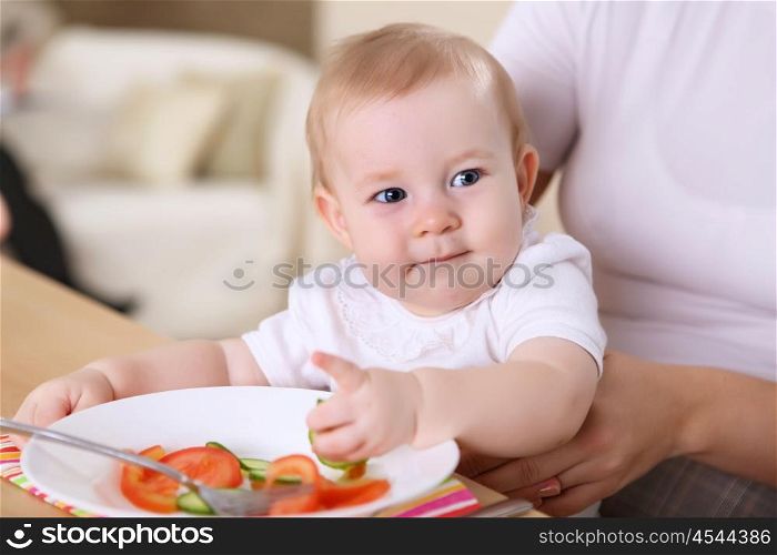 young family at home having meal together with a baby
