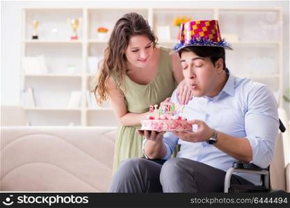 Young family celebrating birthday with disabled person