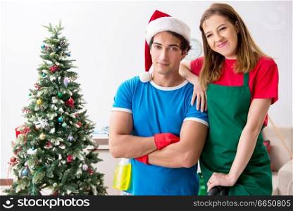 Young family cleaning apartment after christmas party