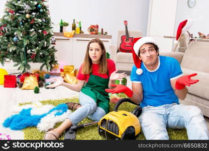 Young family cleaning apartment after christmas party