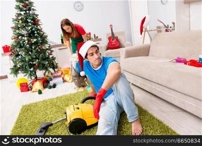 Young family cleaning apartment after christmas party