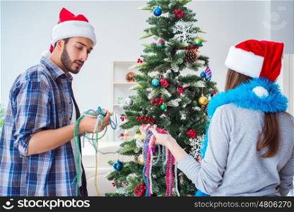 Young family decorating christmas tree on happy occasion