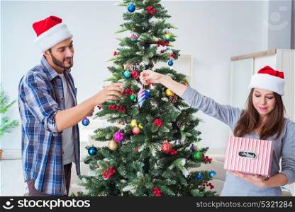 Young family decorating christmas tree on happy occasion