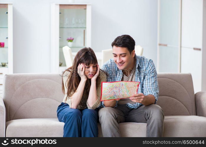 Young family discussing travel plans with map