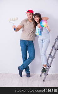 Young family doing renovation at home - painting walls