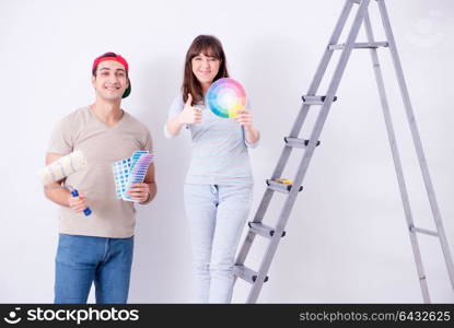 Young family doing renovation at home - painting walls