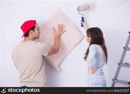 Young family doing renovation at home with new wallpaper