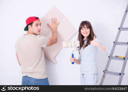 Young family doing renovation at home with new wallpaper