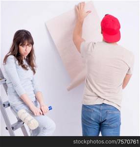 Young family doing renovation at home with new wallpaper. The young family doing renovation at home with new wallpaper
