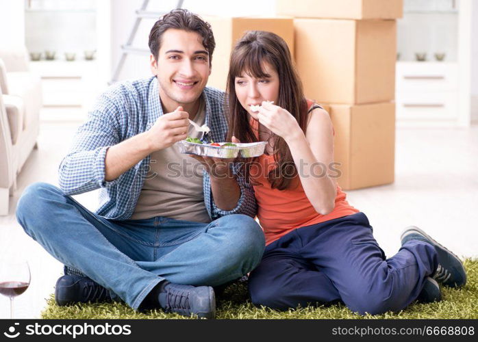 Young family eating food in new apartment after moving in