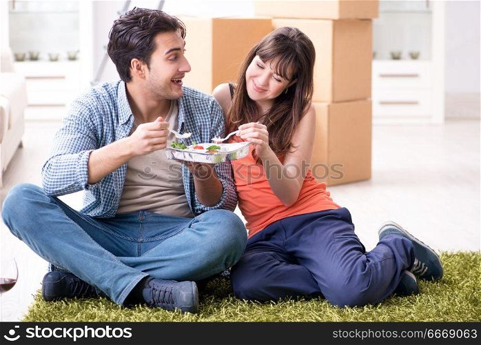 Young family eating food in new apartment after moving in