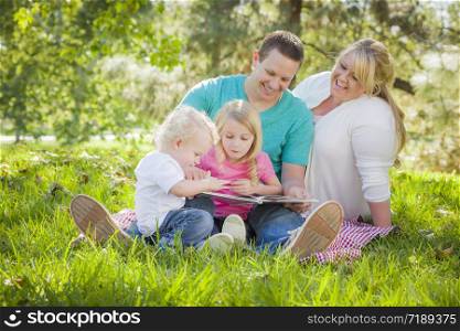 Young Family Enjoys Reading a Book Together in the Park.