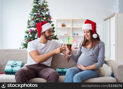 Young family expecting child baby celebrating christmas