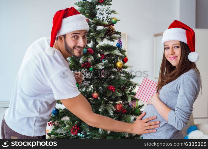 Young family expecting child baby celebrating christmas