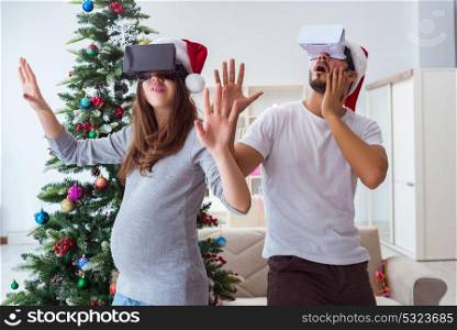 Young family expecting child baby wearing virtual reality VR glasses. Young family expecting child baby wearing virtual reality VR gla