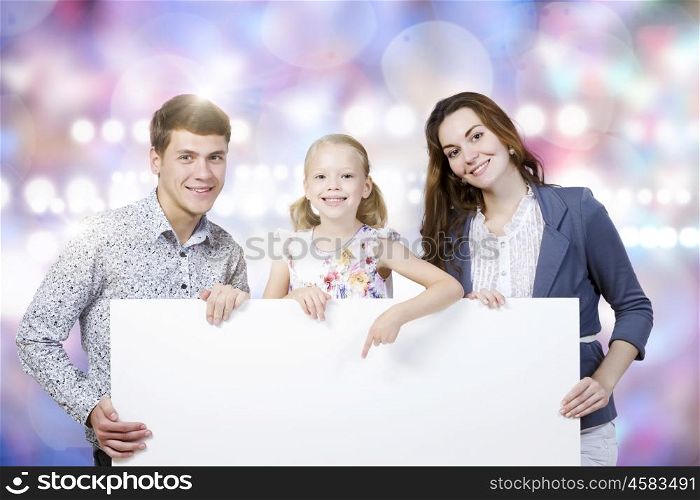 Young family. Happy family of three holding white blank banner. Place for text
