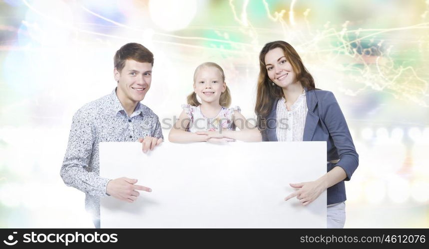 Young family. Happy family of three holding white blank banner. Place for text