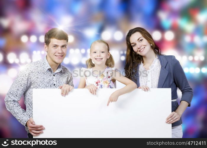 Young family. Happy family of three holding white blank banner. Place for text