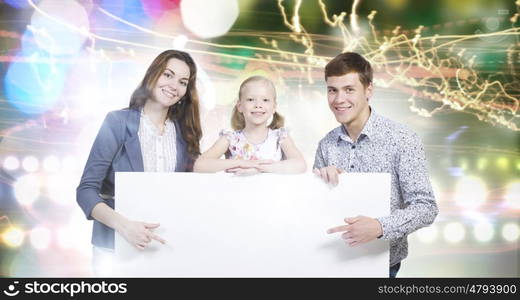 Young family. Happy family of three holding white blank banner. Place for text