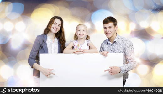 Young family. Happy family of three holding white blank banner. Place for text