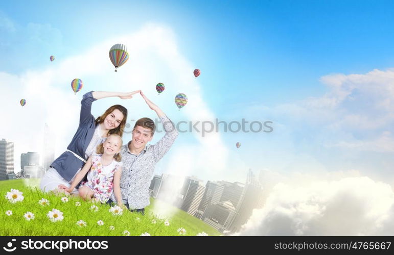 Young family. Happy family of three lying on green grass